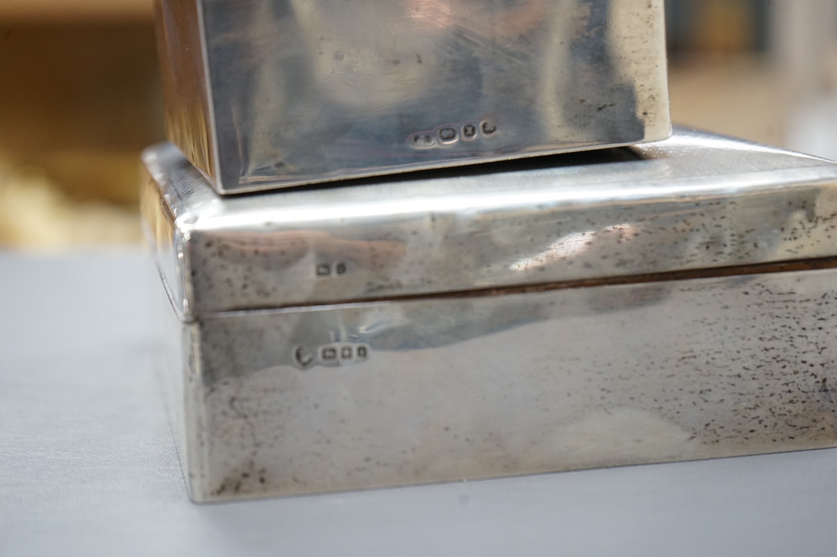 A George V silver mounted rectangular cigarette box, London, 1924, width 16cm, together with a smaller silver mounted cigarette box and a silver cigarette case.